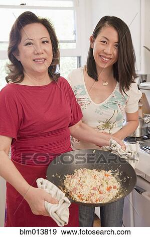 Stock Photo - Chinese mother and daughter cooking together. Fotosearch