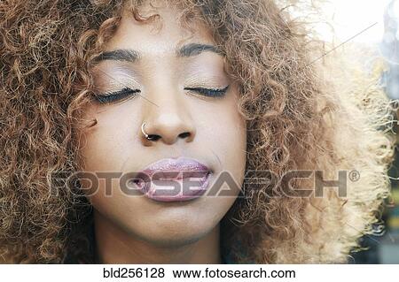 Stock Photo - Close up of black woman with eyes closed. Fotosearch