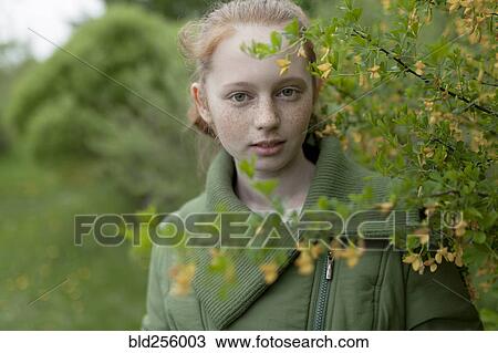 Close up of Caucasian girl standing near branch View Large Photo Image Stock Image - Close up of Caucasian girl standing near branch. Fotosearch