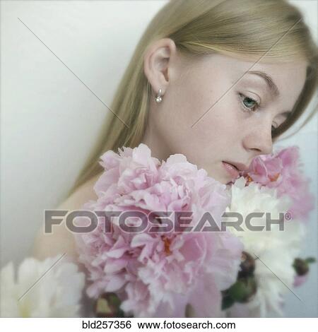 Stock Photograph - Close up of Caucasian teenage girl holding flowers. Fotosearch