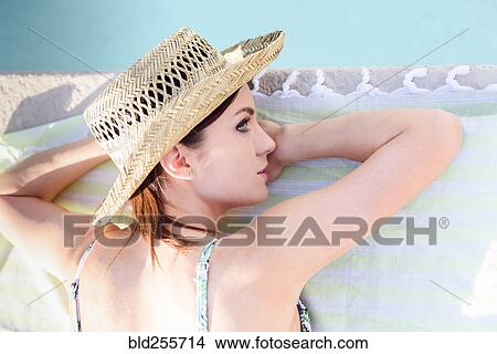 Picture - Close up of Caucasian woman laying near swimming pool. Fotosearch