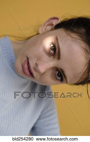 Stock Image - Close up of Caucasian woman tilting head. Fotosearch