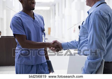 Close up of doctor and nurse shaking hands View Large Photo Image Stock Photo - Close up of doctor and nurse shaking hands. Fotosearch