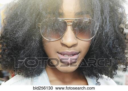Stock Image - Close up of mixed race woman wearing sunglasses. Fotosearch