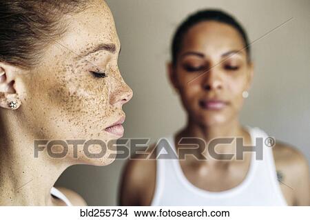 Picture - Close up of mixed race women with eyes closed. Fotosearch