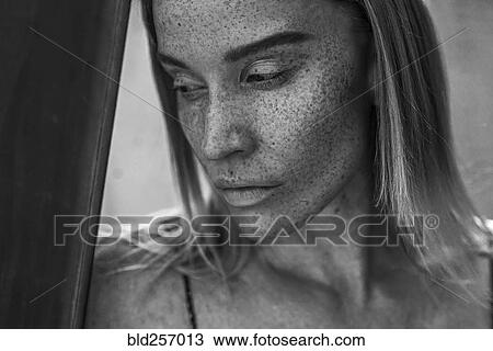 Stock Image - Close up of pensive Caucasian woman with freckles. Fotosearch