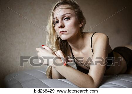 Close up of serious Caucasian woman resting on bed View Large Photo Image Stock Photo - Close up of serious Caucasian woman resting on bed. Fotosearch