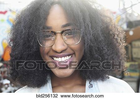 Stock Image - Close up of smiling mixed race woman wearing eyeglasses. Fotosearch