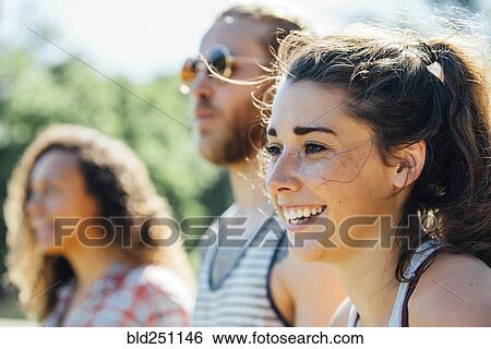 Stock Photograph - Close up of smiling woman with friends. Fotosearch