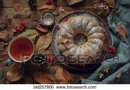 Stock Image - Close up of tea and cake with powdered sugar. Fotosearch