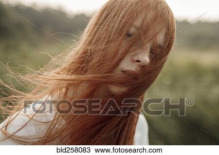 Stock Image - Close up of wind blowing hair of Caucasian woman. Fotosearch