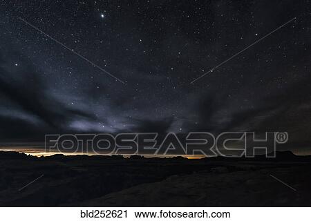 Stock Image - "Clouds and stars in sky over desert, Moab, Utah, United States". Fotosearch