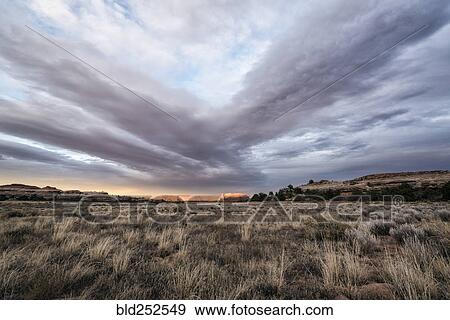 Stock Photo - "Clouds over desert in Moab, Utah, United States". Fotosearch