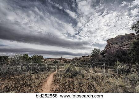 "Clouds over path in desert, Moab, Utah, United States" View Large Photo Image Stock Photo - "Clouds over path in desert, Moab, Utah, United States". Fotosearch