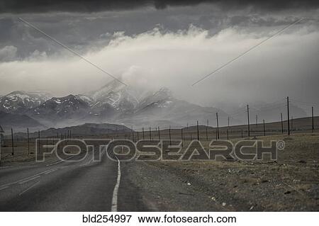Clouds over road to mountain landscape View Large Photo Image Stock Photo - Clouds over road to mountain landscape. Fotosearch