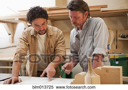 Stock Photography - Co-workers woodworking in workshop. Fotosearch