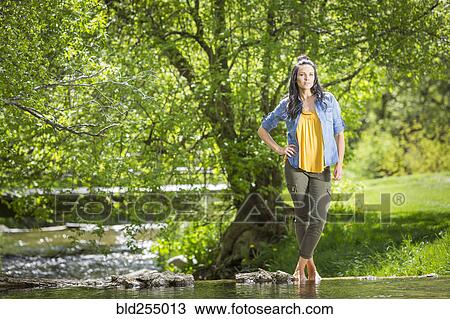 Stock Image - Coffin Caucasian woman standing near river. Fotosearch