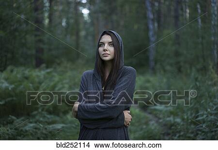 Cold Caucasian woman standing in forest View Large Photo Image Picture - Cold Caucasian woman standing in forest. Fotosearch