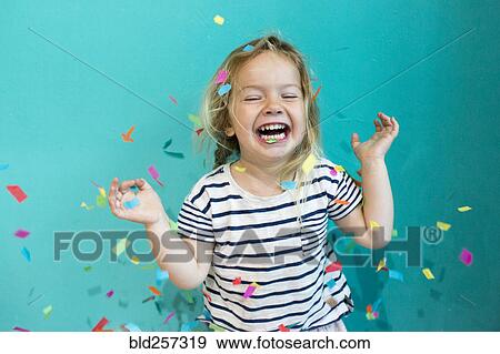 Stock Photo - Colorful confetti falling on Caucasian girl. Fotosearch