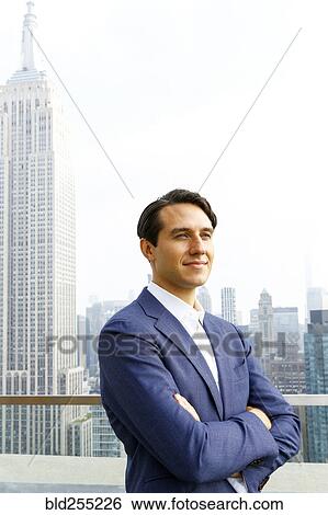 Stock Photograph - Confident Caucasian businessman on urban sidewalk. Fotosearch