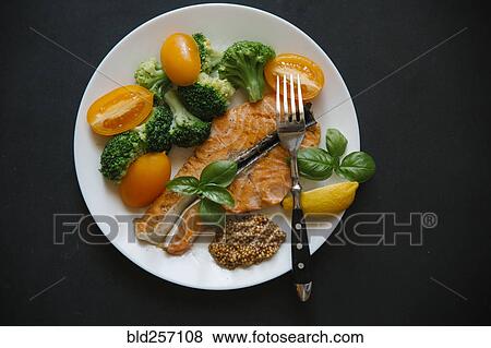 Cooked salmon on plate with broccoli and tomatoes View Large Photo Image Stock Photo - Cooked salmon on plate with broccoli and tomatoes. Fotosearch
