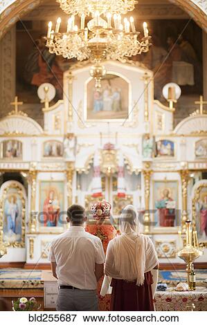 Couple and priest standing in church View Large Photo Image Stock Photo - Couple and priest standing in church. Fotosearch