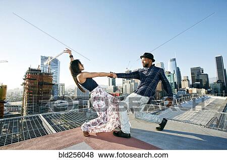Stock Photo - Couple dancing on urban rooftop. Fotosearch