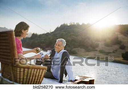 Stock Image - Couple enjoying wine at waterfront. Fotosearch