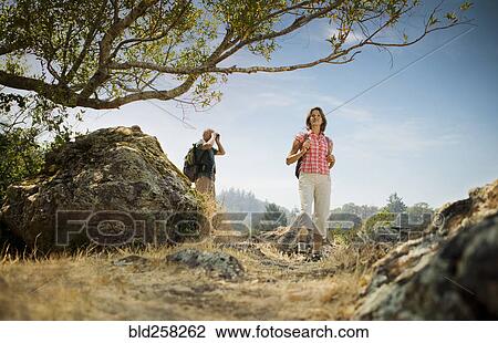 Couple hiking near rocks View Large Photo Image Stock Image - Couple hiking near rocks. Fotosearch