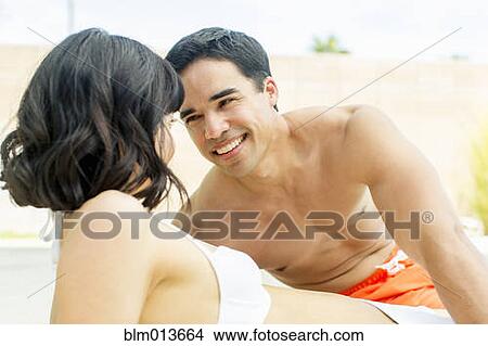 Picture - Couple in bathing suits flirting. Fotosearch