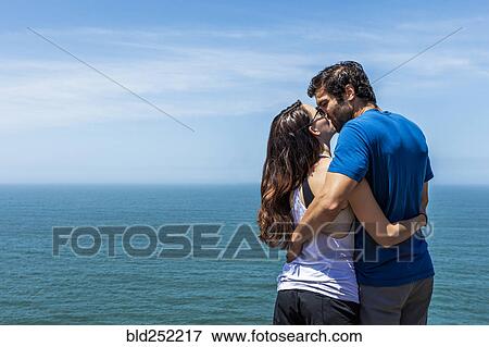 Stock Photo - Couple kissing near ocean. Fotosearch