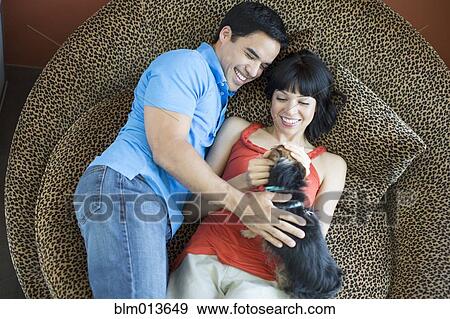 Couple laying together petting dog View Large Photo Image Stock Photo - Couple laying together petting dog. Fotosearch