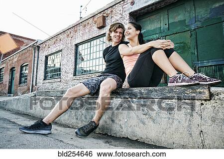 Stock Photograph - Couple resting on loading dock. Fotosearch