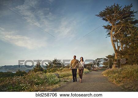 Stock Photograph - Couple walking on path in park. Fotosearch