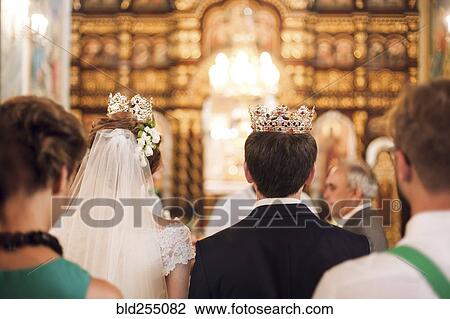 Couple wearing crowns in church View Large Photo Image Stock Image - Couple wearing crowns in church. Fotosearch