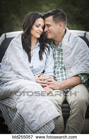 Couple wrapped in blanket sitting on bed of pick-up truck View Large Photo Image Stock Photo - Couple wrapped in blanket sitting on bed of pick-up truck. Fotosearch
