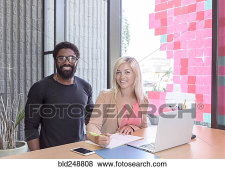 Creative business people posing with laptop at table View Large Photo Image Stock Photo - Creative business people posing with laptop at table. Fotosearch