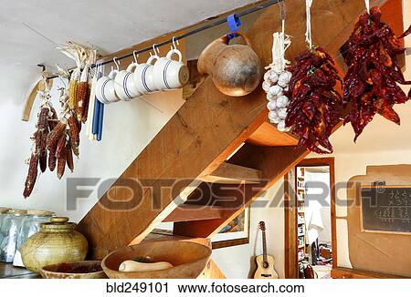 Stock Image - Cups and dried food hanging in traditional indigenous kitchen. Fotosearch