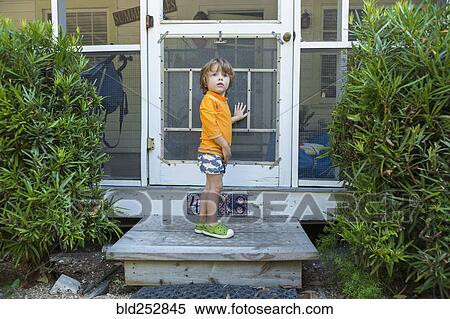 Curious Caucasian boy standing at screen door View Large Photo Image Stock Photography - Curious Caucasian boy standing at screen door. Fotosearch