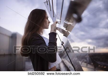 Curious Caucasian woman peering over glass wall at scenic view View Large Photo Image Stock Image - Curious Caucasian woman peering over glass wall at scenic view. Fotosearch
