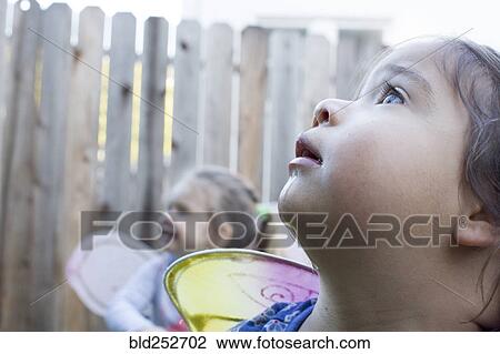 Stock Image - Curious girls wearing fairy wings outdoors. Fotosearch