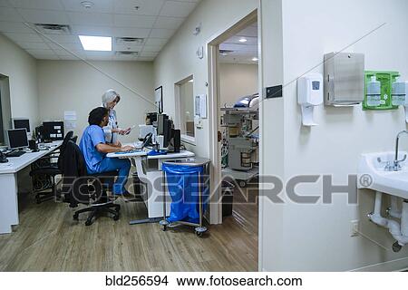 Picture - Doctor and nurse discussing digital tablet. Fotosearch