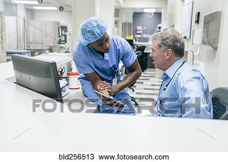 Doctor and nurse discussing digital tablet View Large Photo Image Stock Image - Doctor and nurse discussing digital tablet. Fotosearch