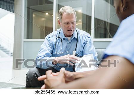 Stock Photography - Doctor and nurse discussing digital tablet. Fotosearch