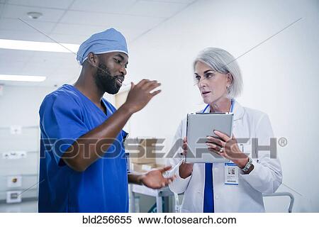 Doctor and nurse discussing digital tablet View Large Photo Image Stock Photography - Doctor and nurse discussing digital tablet. Fotosearch