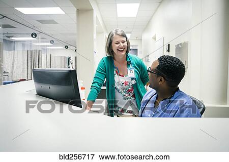 Stock Photo - Doctor and nurse laughing near computer. Fotosearch