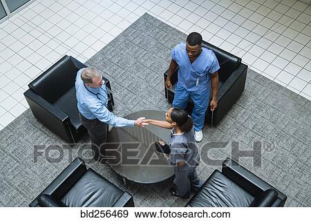 Stock Photo - Doctor and nurse shaking hands. Fotosearch