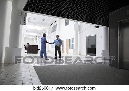 Stock Photo - Doctor and nurse shaking hands. Fotosearch