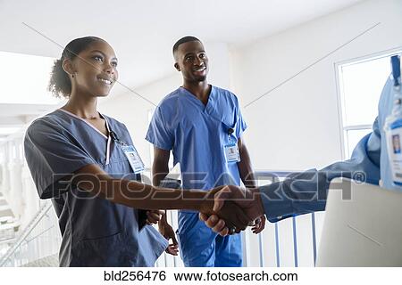 Stock Photograph - Doctor and nurse shaking hands. Fotosearch