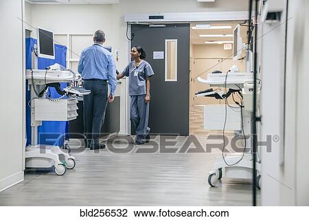 Stock Image - Doctor and nurse talking in hospital. Fotosearch